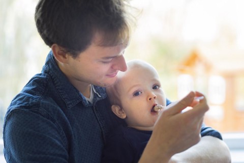 Subject: Father feeding his child at the age of nine months.