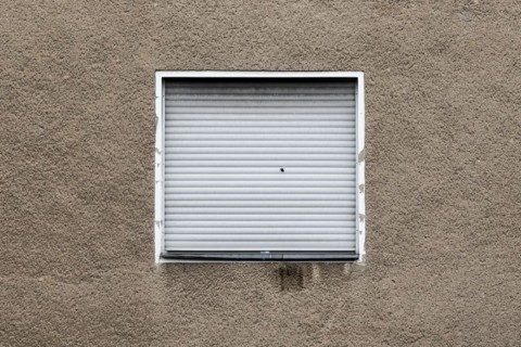 Lowered blinds stand out at an abandoned residential building in Berlin