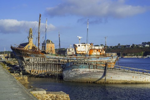 Tourists visiting wrecks of old wooden trawler fishing boats
