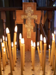 Burning candles in front of a cross in the Russian Chapel
