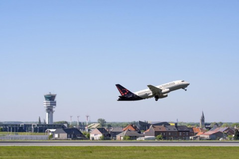 Control tower of Brussels Airport and the village Steenokkerzeel behind runway of Brussels Airlines while airplane is taking off