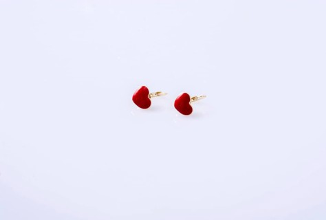 Red color heart shaped earring on white background