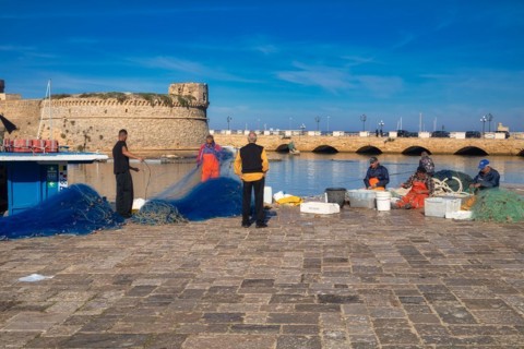 Fishermen in front of Castelo in the fishing port of Gallipoli