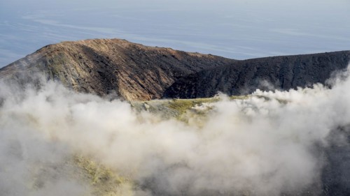 Smoking sulphur fumaroles at the crater rim