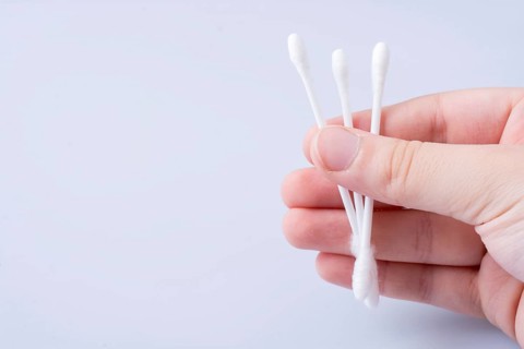 A few ear sticks in hand isolated on white background