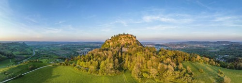 Aerial panorama of the volcanic cone Hohentwiel with the castle ruins illuminated by the evening sun