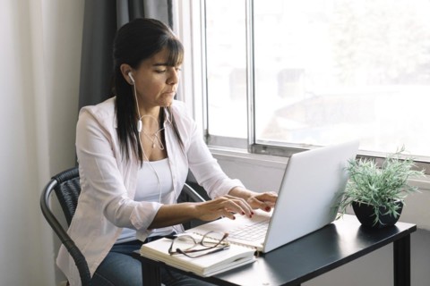 Businesswoman working on laptop computer sitting at home and managing her business through home office during Coronavirus or Covid-19 quarantine