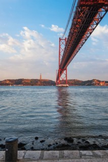 View from under of 25 de Abril Bridge famous tourist landmark over Tagus river