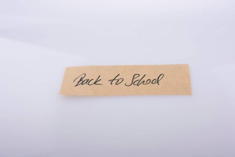 Back to school written on a note paper on white bakcground