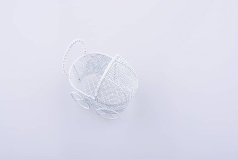 Toy baby carriage made of metal on white background