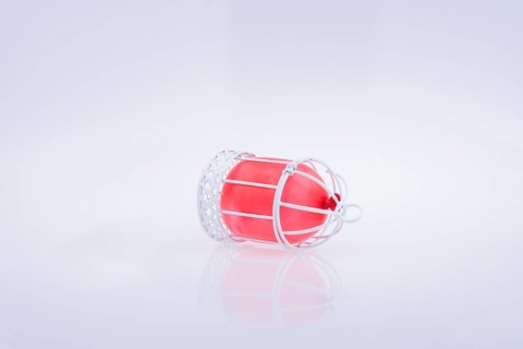 Little red balloon placed in a white color bird house with metal bars