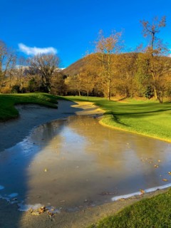 Sand Trap with Ice and Trees and Mountain with Sky and Sunlight in Lugano