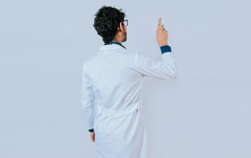 Doctor posing from back pointing finger. Young doctor from back pointing finger isolated