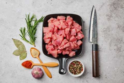 Top view of raw pork goulash in ceramic pan