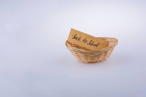 Back to school written on a note paper in a wooden basket