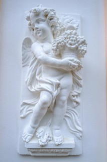 Childlike angel figure on the wall of a noble architecture in the villa district of Sassnitz