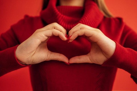 Female hands make a heart shape