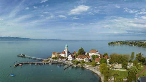 Aerial panorama of the moated castle peninsula on Lake Constance with the baroque church of St. George