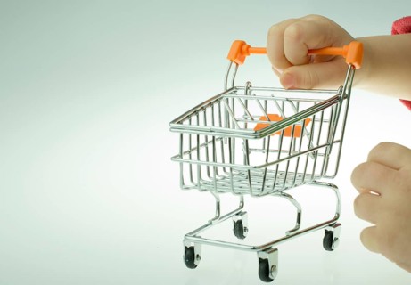 Shopping cart in the hand on white background