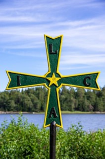 Old historical iron cross of paws with Masonic symbolism in a grove in front of Laeckoe Castle by Lake Vaenern