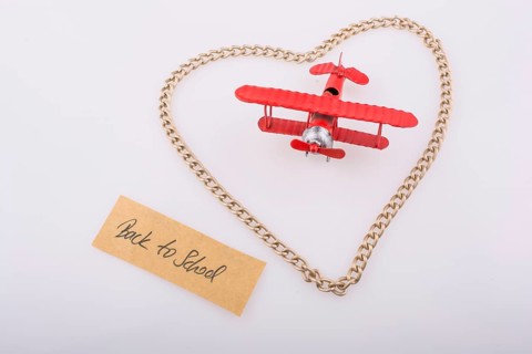 Chain forms a heart shape with a title back to school in it with a red model airplane