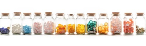 Seamless tileable rows of medicine and drug bottles with pills on a white background