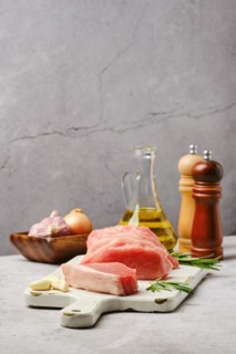 Fresh uncooked pork loin roast on grey background