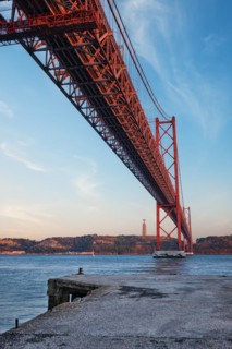 View from under of 25 de Abril Bridge famous tourist landmark over Tagus river