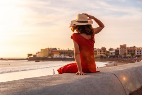 Tourist woman at sunset enjoying vacations on the beach of Valle Gran Rey village in La Gomera