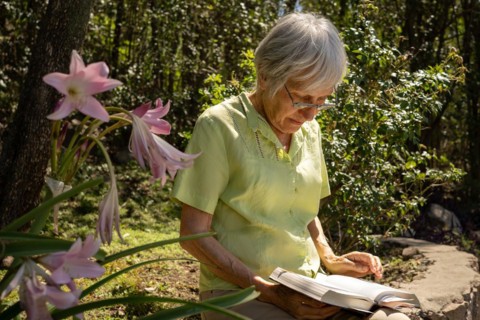 Serious mature woman reading in her garden