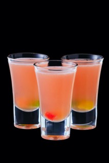 Three vodka shots with sweet jelly isolated on black background