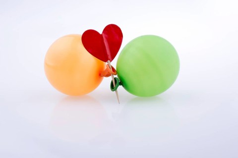 Red heart and colorful small balloons on a white background