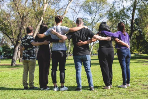 Rear view of a group of hugging friends. Friendship and support concept