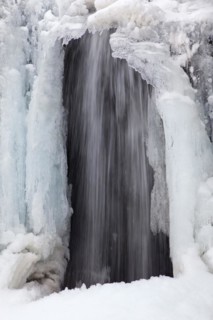 Frozen waterfall Kirkjufellsfoss on the Snaefellsnes peninsula in winter