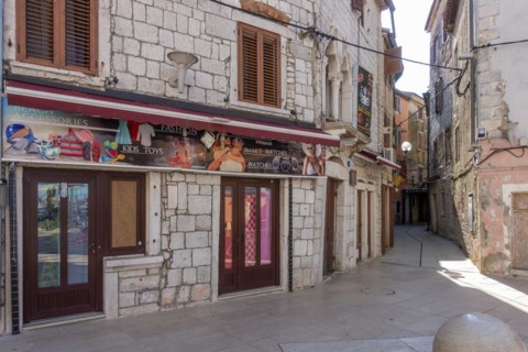 Advertising posters on old stone houses in the coastal town of Umag
