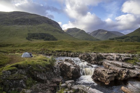 Wild camping with lightweight dome tent along the River Etive in Glen Etive near Glencoe in the Scottish Highlands