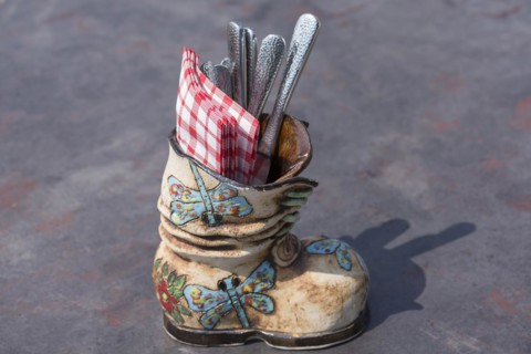 Ceramic boots as cutlery and napkin holder in a restaurant