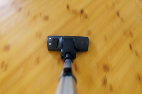 Symbolic photo on the subject of housework. A hoover sucks dust on a floorboard. Berlin