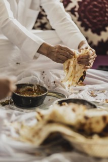 A man in traditional dress photographed with the Yemeni bread Malawach in Jeddah