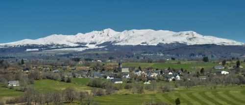 Regional natural park of the Volcanoes of Auvergne. View on the village of Saint Genes Champespe and the Monts Dore in winter. Puy de Dome department. Auvergne-Rhone-Alpes. France