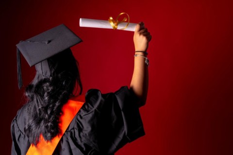Female student in a graduation photo. End of education degree with graduate diploma. University