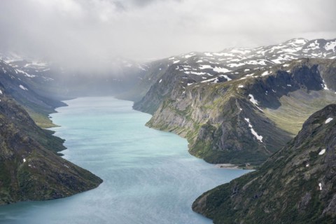 View of Lake Gjende and snowy mountains
