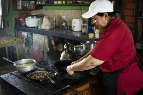 Woman concentrating on cooking in her small Costa Rican typical food business