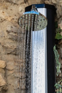 Shower in the street over a stone wall spraying water