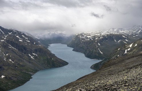 View of Lake Gjende and snowy mountains