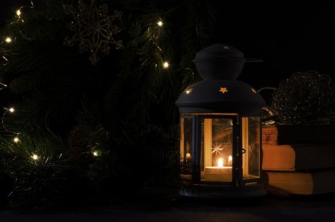 White lantern with a burning candle. Books