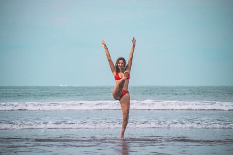 Young woman in red bikini having fun and feeling free in the turquoise sea