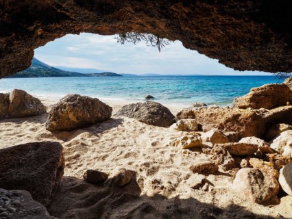 Karst cave on the sandy beach near the campsite of Stara Baska