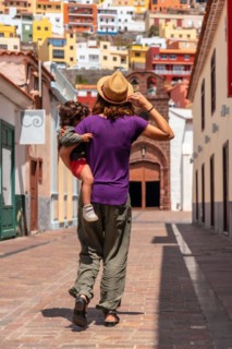 Mother with her son in her arms in the city of San Sebastian de la Gomera next to the Iglesia De La Asuncion
