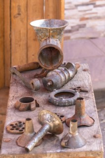 Antique sausage making machine with all its accessories on a wood table